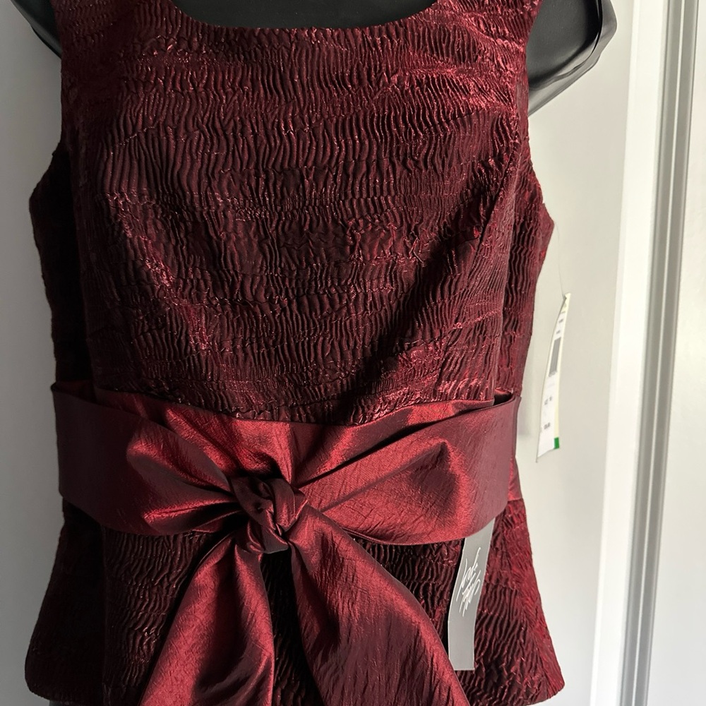 La Nuit pleated sleeveless top size 10 
burgundy NWT with tied bow at waist.